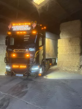 Vrachtwagen van Bedding Express bij strooisel in een loods