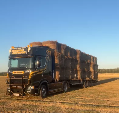 Plateauwagen met vlasbalen op een veld