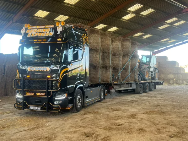 Plateauwagen met vlasbalen in een loods